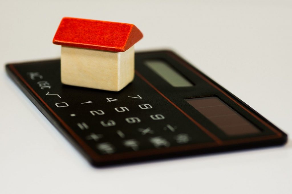 calculatrice sur laquelle est posée une maison miniature